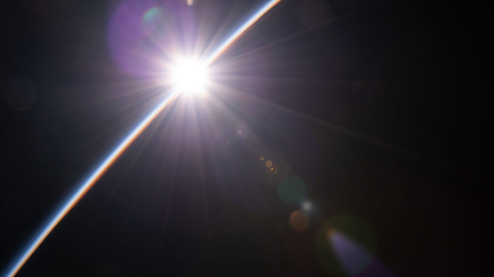 Sunlight breaking across Earth's horizon, photographed from orbit.